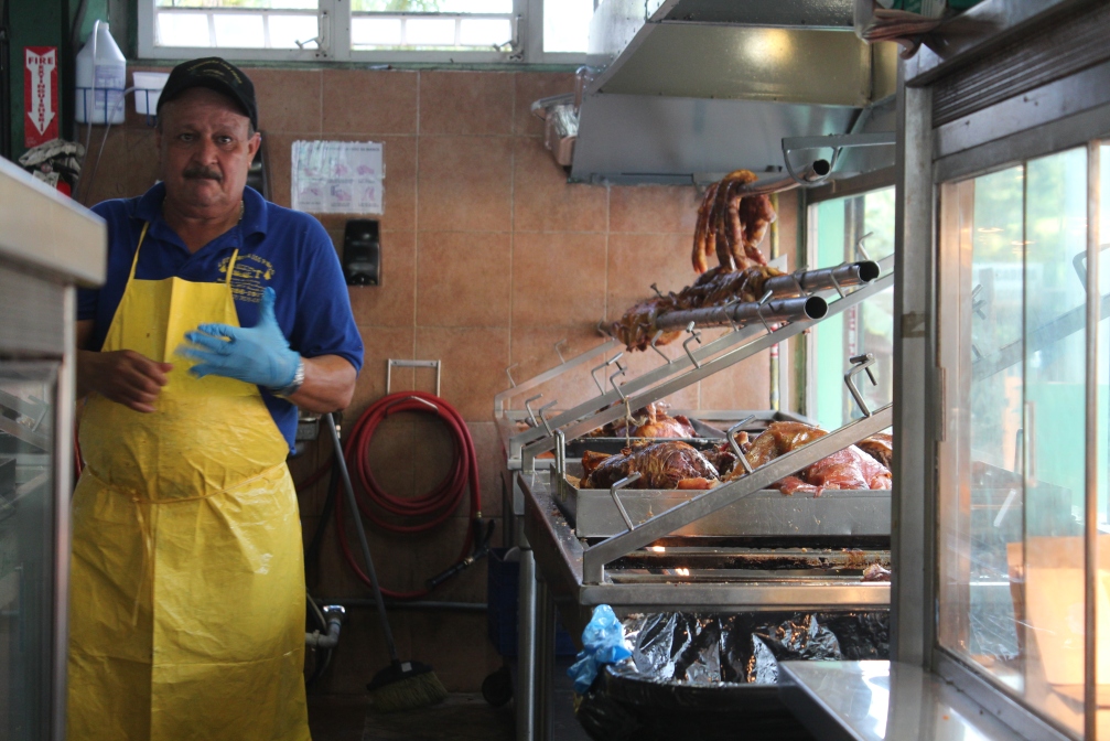 Hog butcher changes gloves, Lechonera Los Pinos, Guavate